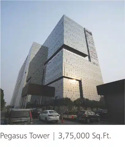 Pegasus Tower completed commercial project with mirrored glass facade, angular volumes and parked cars at the entrance