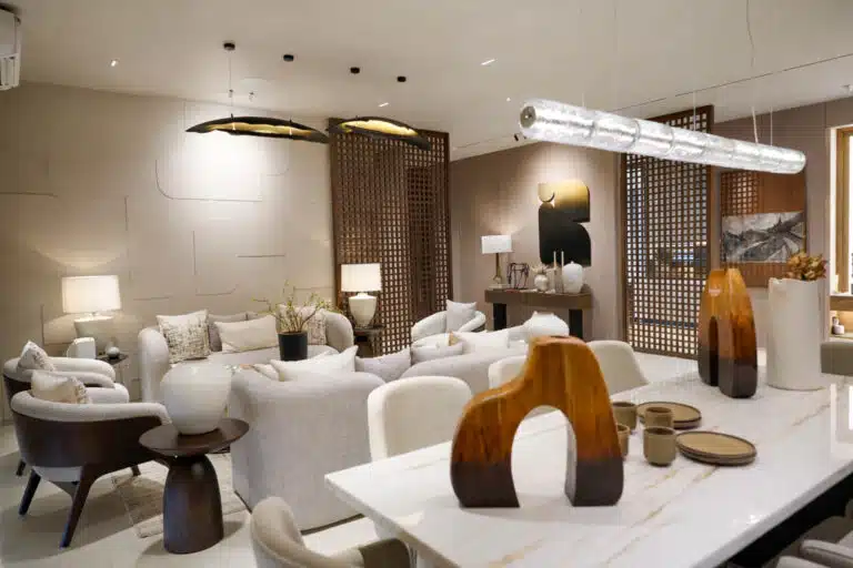 Elegant Gulnaar Zenium living and dining space with neutral furnishings, wooden accents and sculptural tabletop pieces