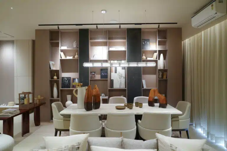 Elegant dining room with built-in shelves, statement pendant light and neutral seating in Gulnaar Zenium luxury apartment