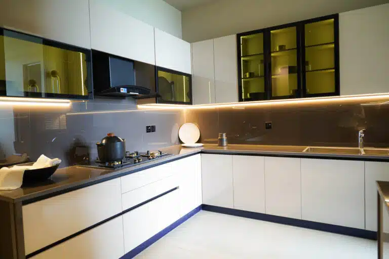 Luxury apartment kitchen with white L-shaped cabinets